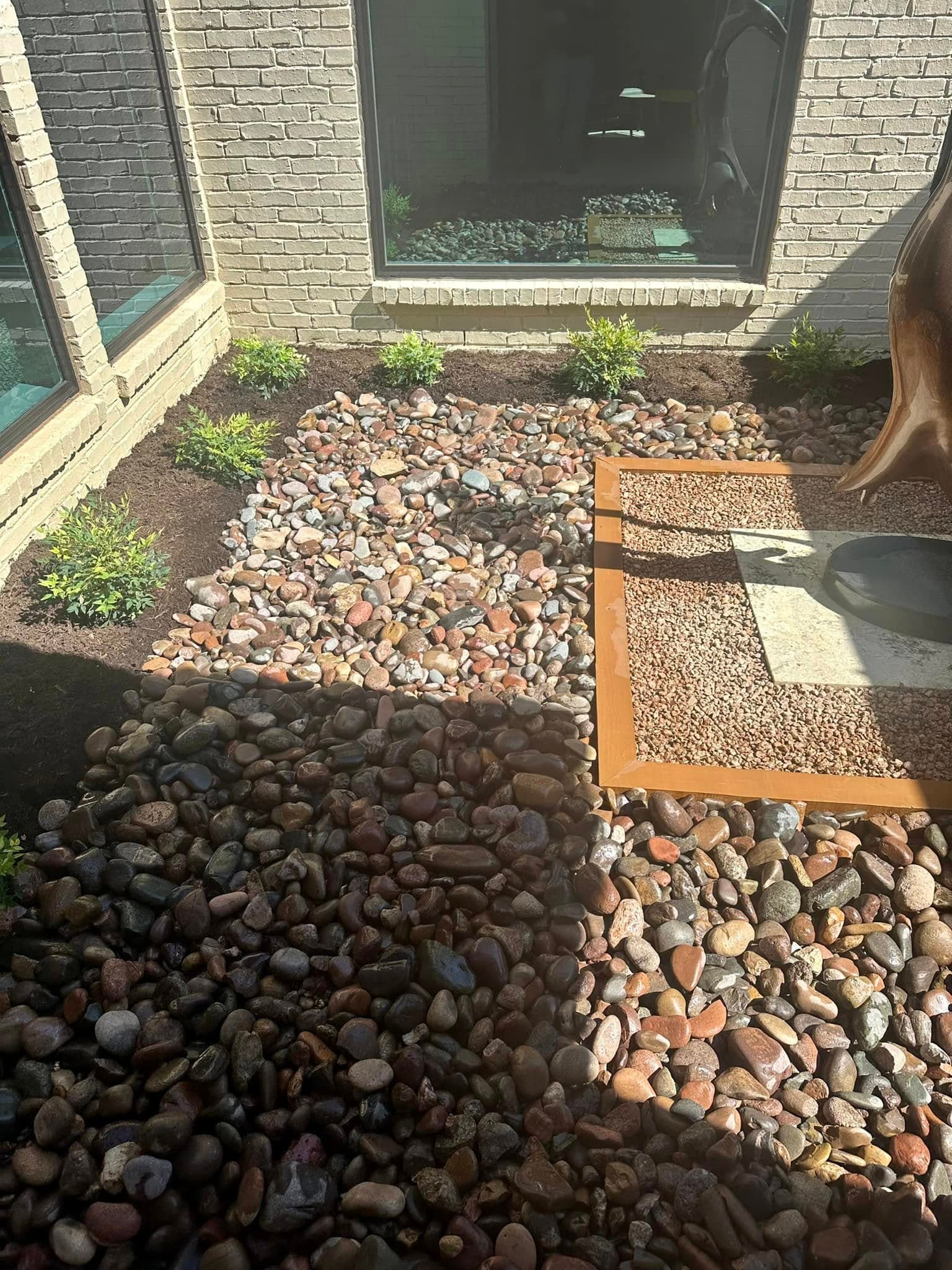 Detailed river-rock border and metal edging in a courtyard landscape