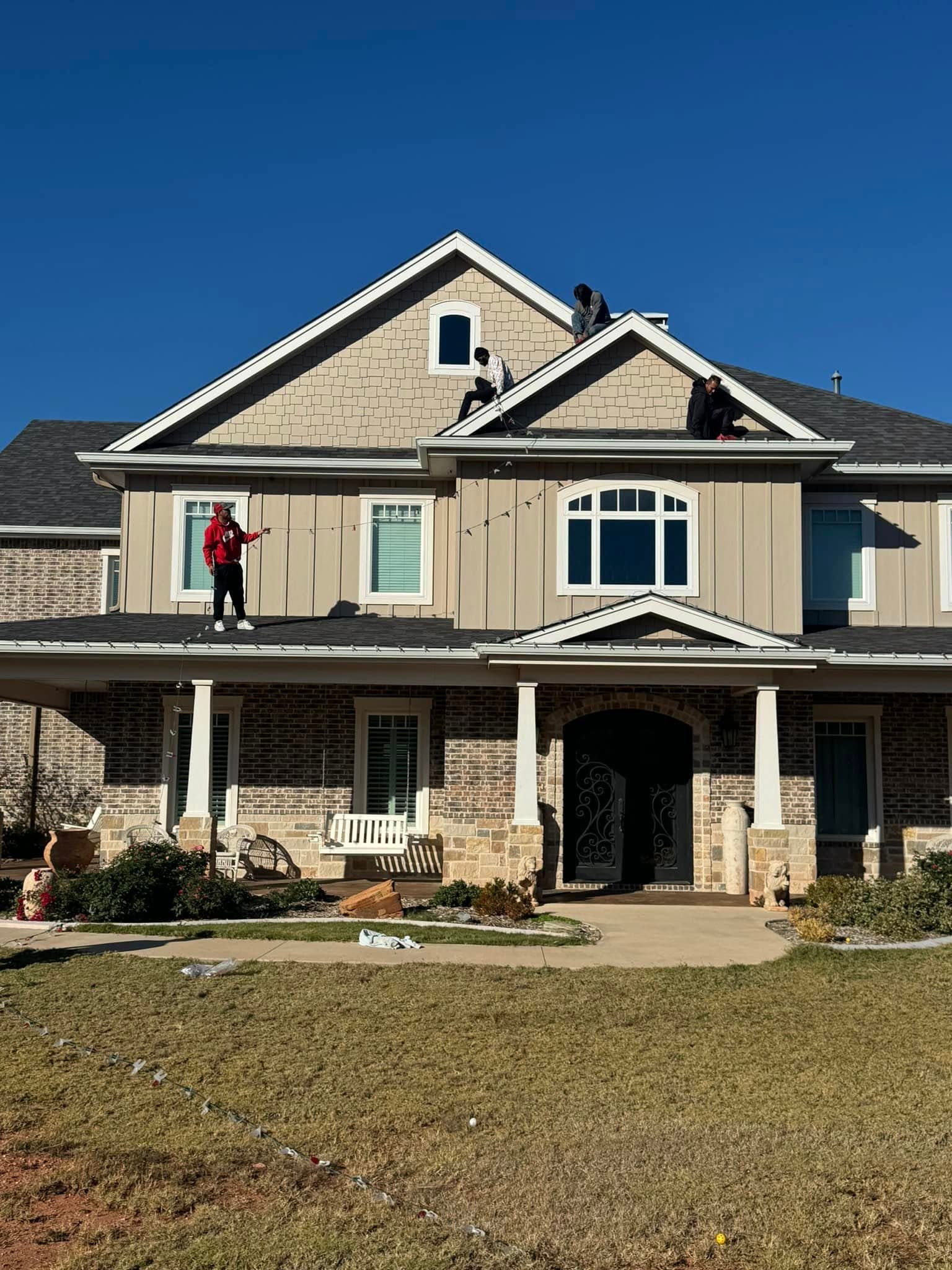West Texas Pride crew installing Christmas lights along a roofline